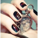 Diseño de uñas con un arcoiris sobre negro