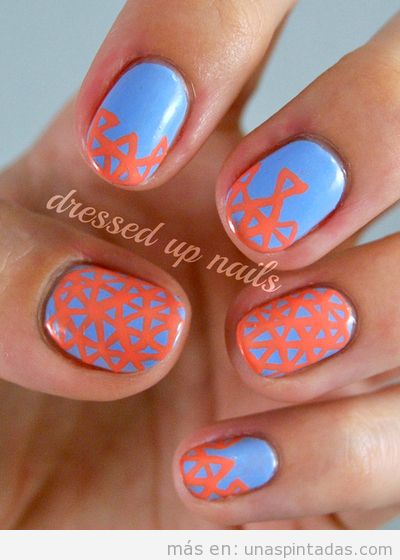 Decoración de uñas dibujos geométricos coral sobre fondo azul