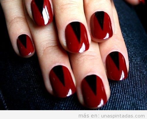 Diseño de uñas gótico en rojo con triángulo negro